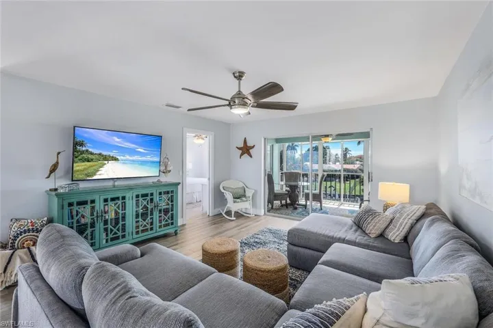 Living room with ceiling fan and hardwood / wood-style floors