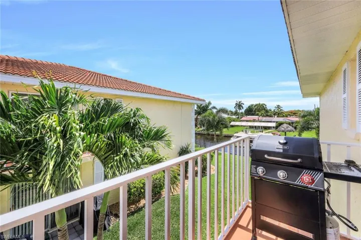 Balcony with a water view and area for grilling