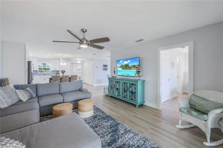 Living room with ceiling fan and light hardwood / wood-style flooring