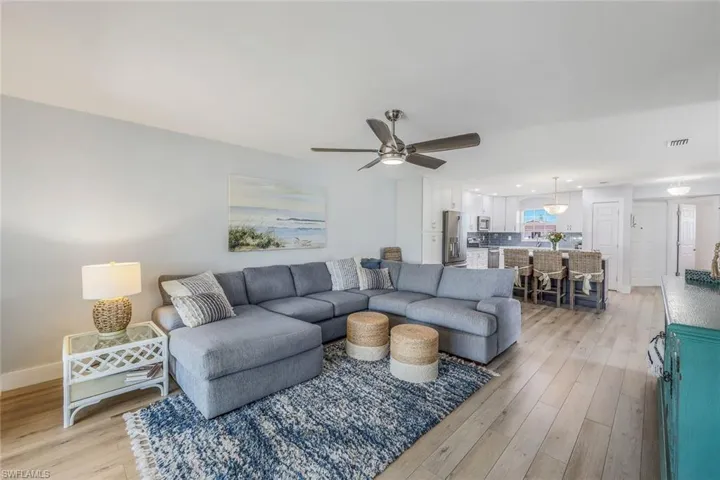 Living room with ceiling fan and light hardwood / wood-style flooring