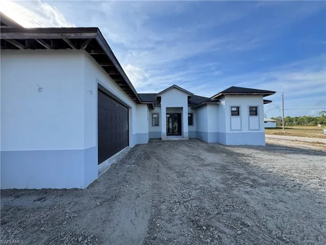 View of front of house with stucco siding and an attached garage