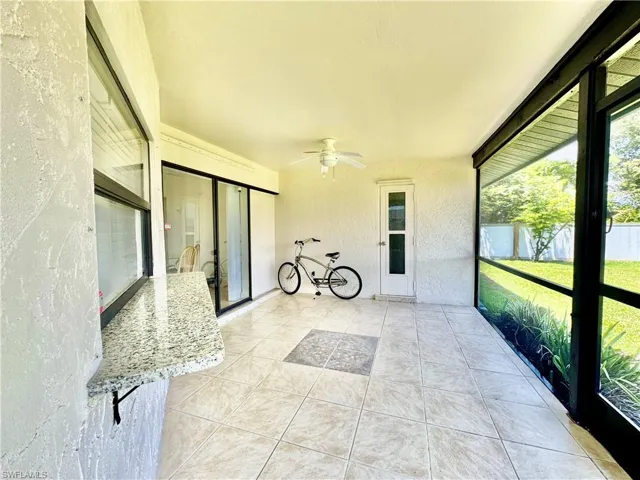 Unfurnished sunroom featuring ceiling fan