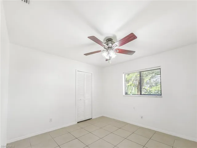 Spare room featuring a ceiling fan, baseboards, and light tile patterned floors