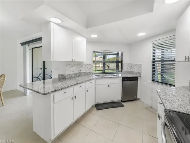 Kitchen with a sink, appliances with stainless steel finishes, tasteful backsplash, white cabinets, and recessed lighting