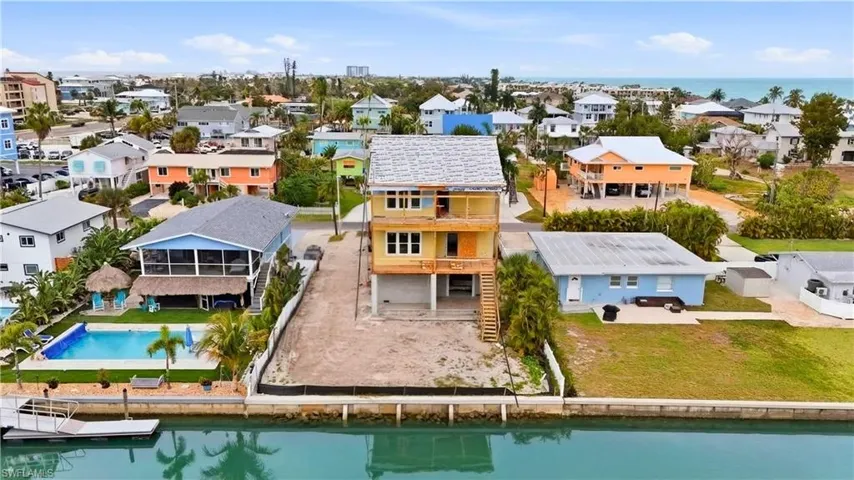 Aerial perspective of suburban area featuring a nearby body of water and a pool - Virtually Edited Image