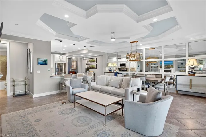 Living room with crown molding, coffered ceiling, a ceiling fan, recessed lighting, and light tile patterned floors