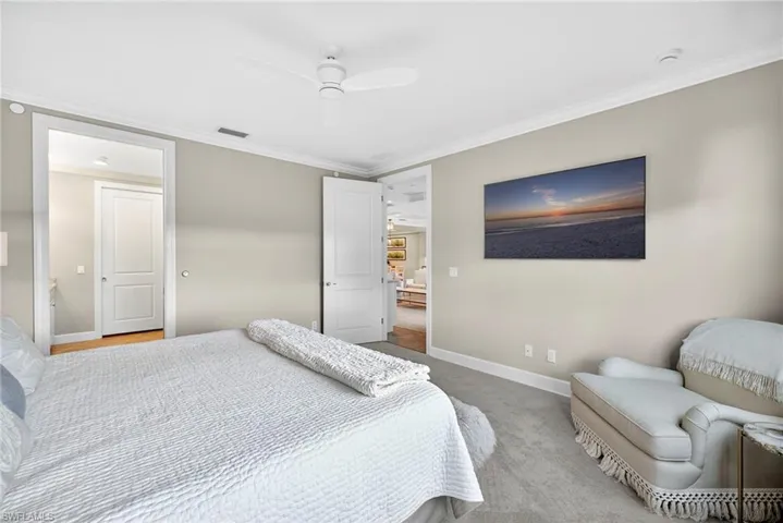 Carpeted bedroom featuring ornamental molding and a ceiling fan