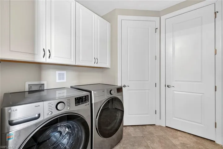 Washroom featuring washing machine and dryer and cabinet space