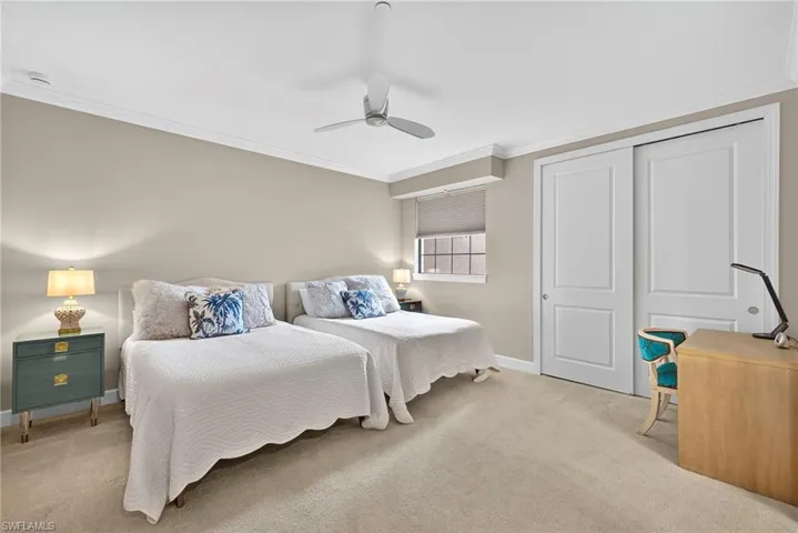 Bedroom with light carpet, ornamental molding, a closet, and ceiling fan