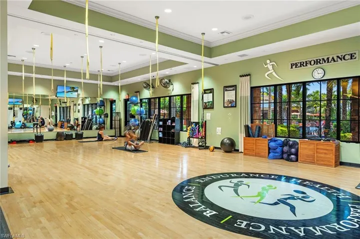 Gym featuring crown molding, a towering ceiling, and recessed lighting