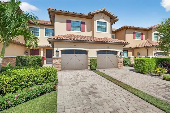 Mediterranean / spanish house with decorative driveway, stucco siding, stone siding, and a tiled roof