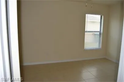 Empty room featuring baseboards and tile patterned flooring