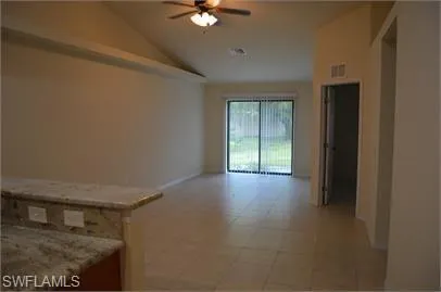 Unfurnished room with a ceiling fan and lofted ceiling