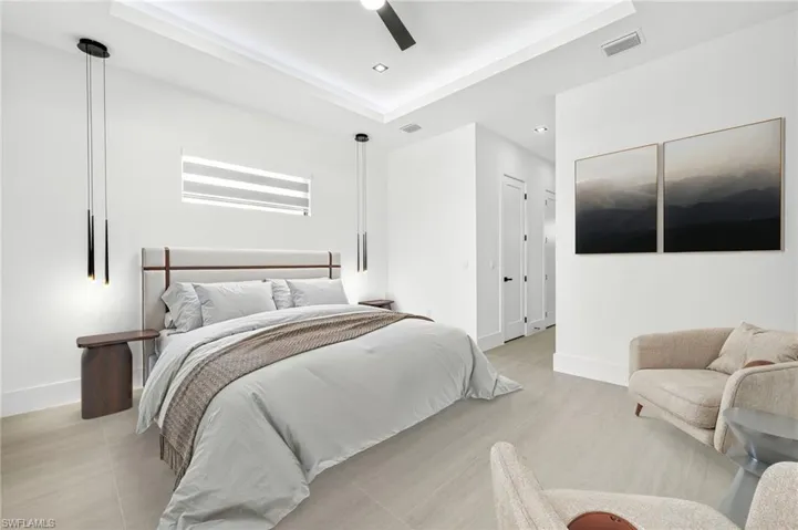 Bedroom featuring a raised ceiling, recessed lighting, and a ceiling fan
