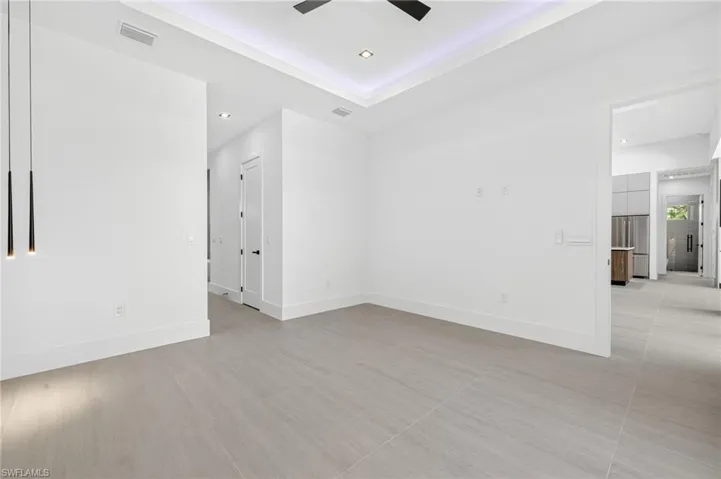 Unfurnished room featuring recessed lighting, ceiling fan, and a tray ceiling