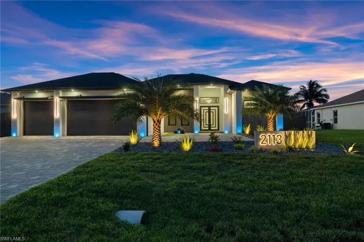 View of front facade featuring french doors, a front yard, decorative driveway, an attached garage, and stucco siding