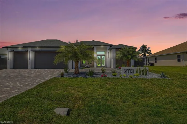 Prairie-style house featuring french doors, a yard, decorative driveway, and an attached garage