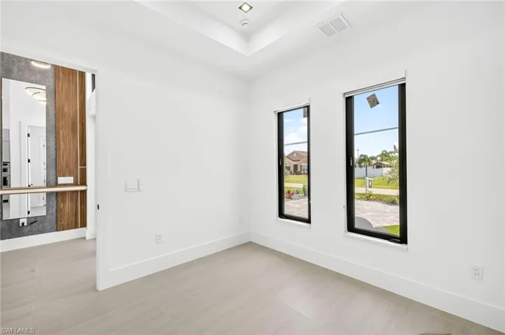 Empty room featuring baseboards and a raised ceiling