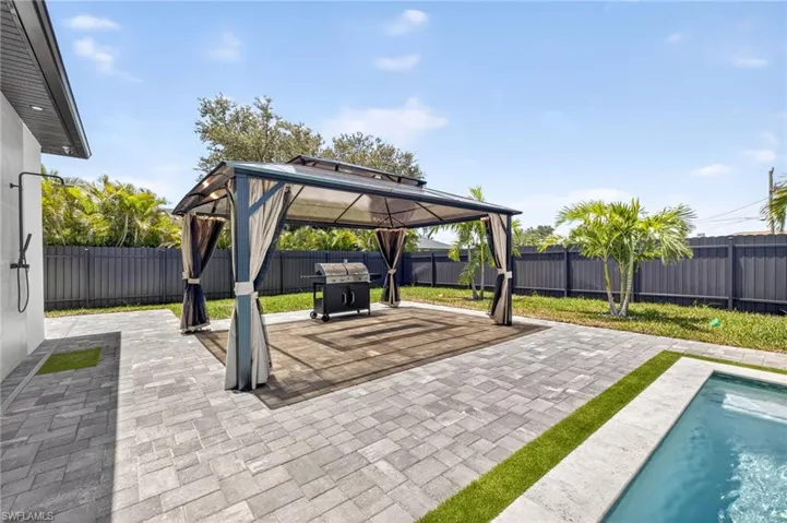 Fenced backyard with a gazebo, a patio area, and a grill