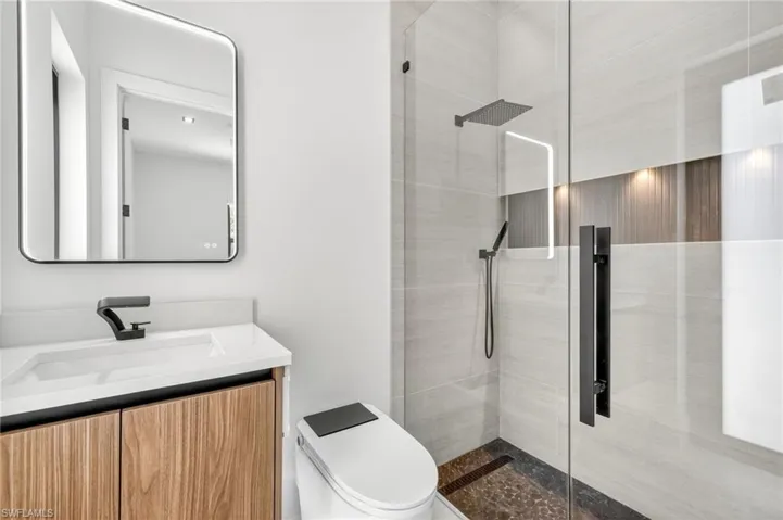 Bathroom with tiled shower and vanity