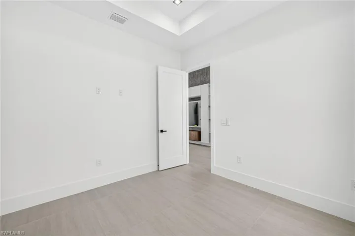 Spare room with light tile patterned floors and a tray ceiling