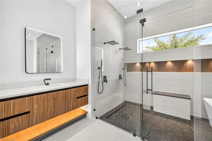 Bathroom featuring a shower stall, vanity, a freestanding tub, and tile patterned floors