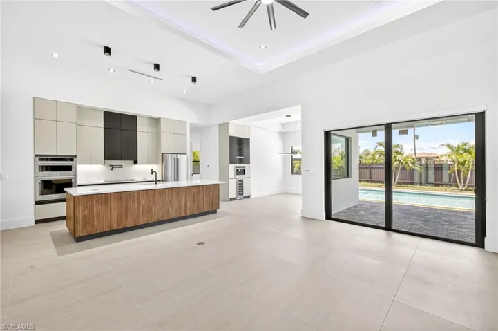 Kitchen featuring modern cabinets, light countertops, open floor plan, a kitchen island with sink, and stainless steel appliances