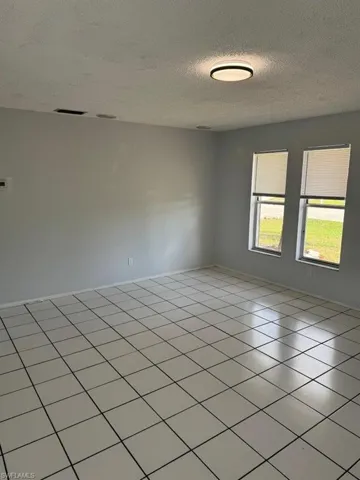 Tiled spare room featuring a textured ceiling