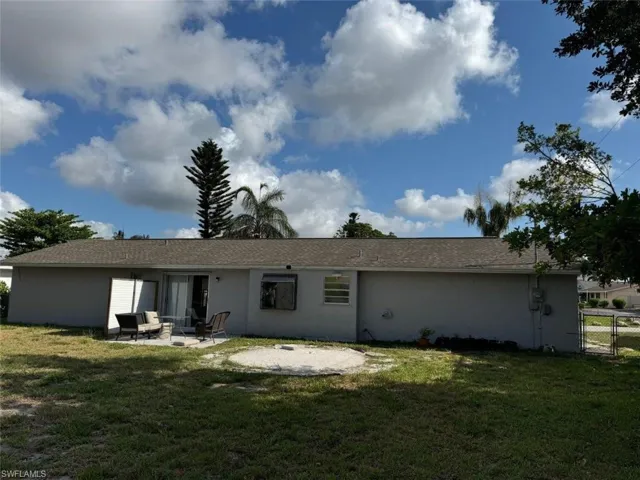 Back of property featuring a patio area and a lawn