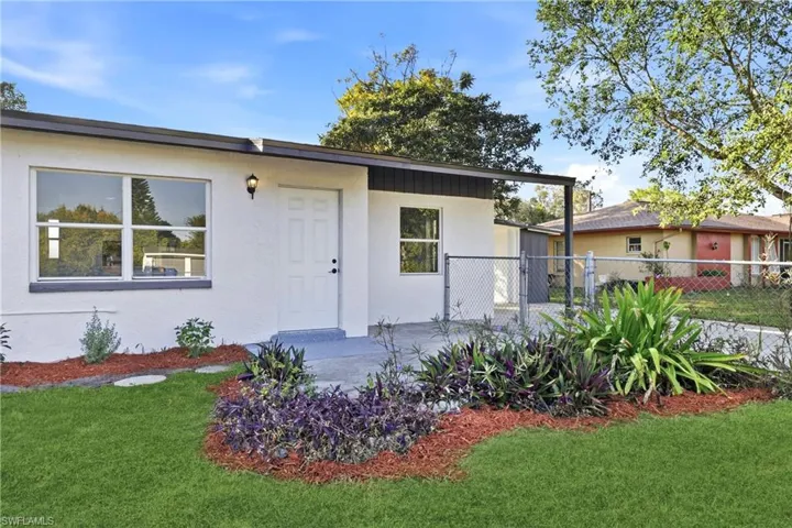 Entrance to property with stucco siding and a gate