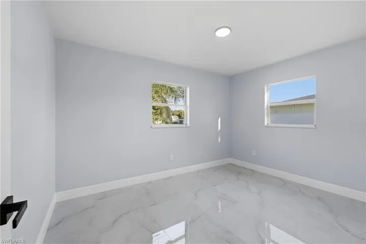 Empty room featuring marble finish floors and plenty of natural light