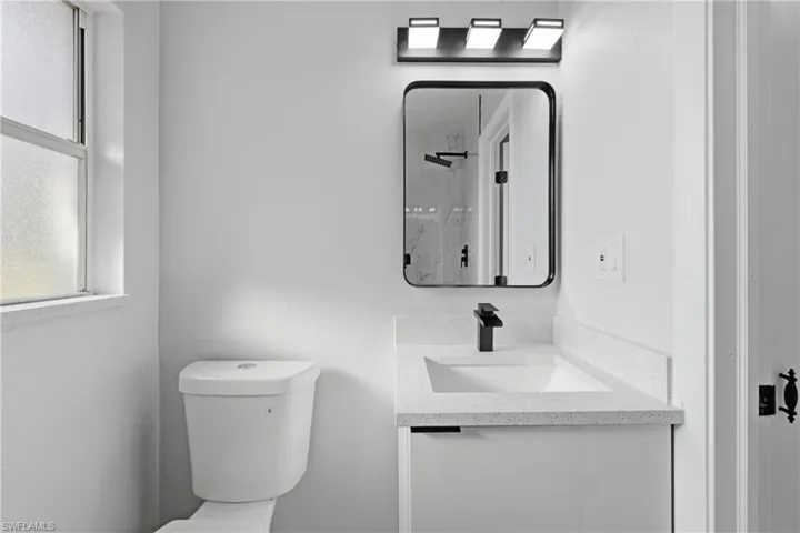 Bathroom featuring vanity and a marble finish shower