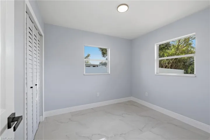 Unfurnished bedroom with light marble finish floors and a closet