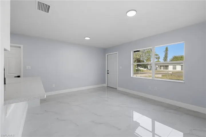 Spare room featuring light marble finish flooring and baseboards