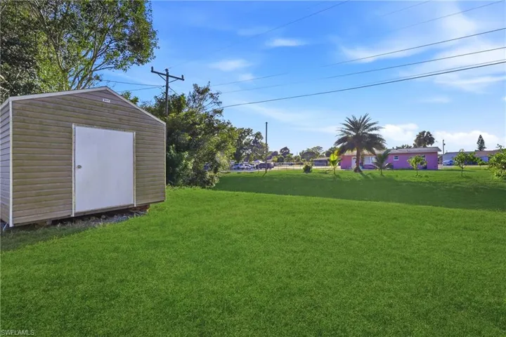 View of green lawn featuring a shed