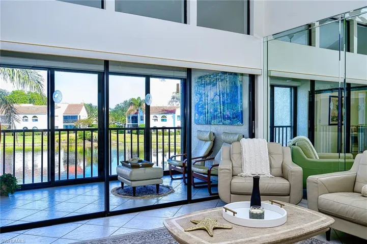 Living room with lanai and lake view hurricane impact outer sliders with new screen and railings installed!