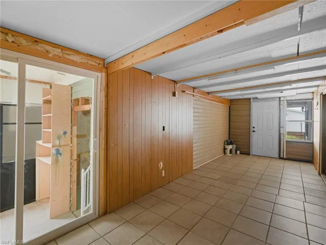 Empty room featuring wooden walls and tile patterned flooring