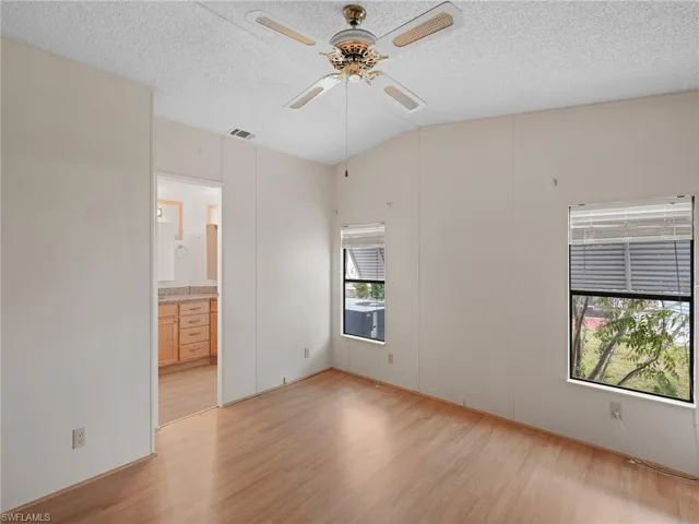 Unfurnished room featuring light wood-style flooring, a ceiling fan, and a textured ceiling