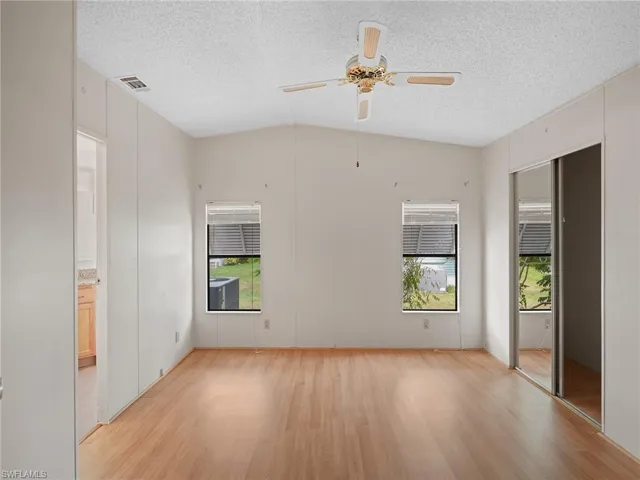 Unfurnished room with light wood finished floors, a textured ceiling, and a ceiling fan