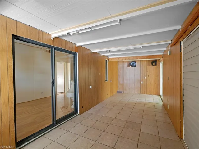 Hall with wood walls and light tile patterned floors