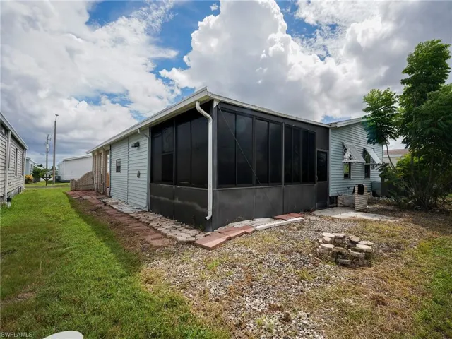 Rear view of property with a sunroom and a lawn