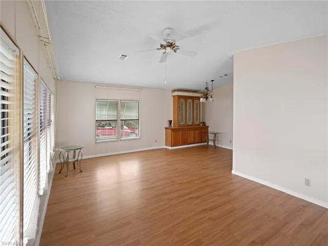Unfurnished living room with a textured ceiling, light wood-style floors, and a ceiling fan