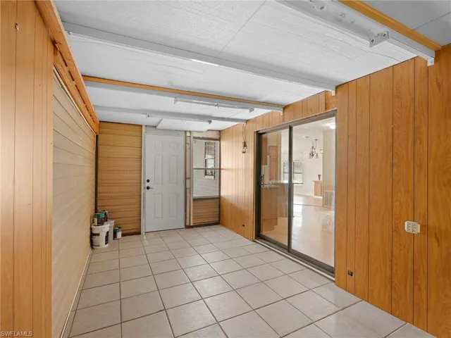Empty room with wooden walls and light tile patterned floors