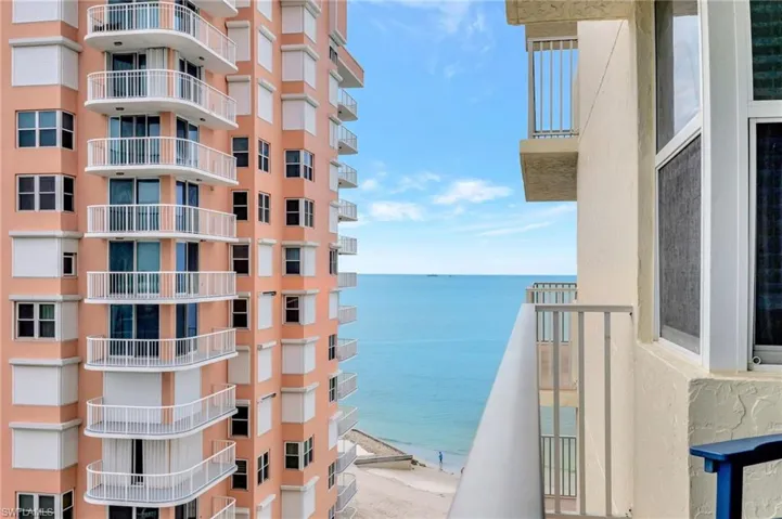 Balcony featuring view of water and beach