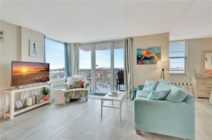 Living area featuring a textured ceiling, expansive windows, and light wood-style floors