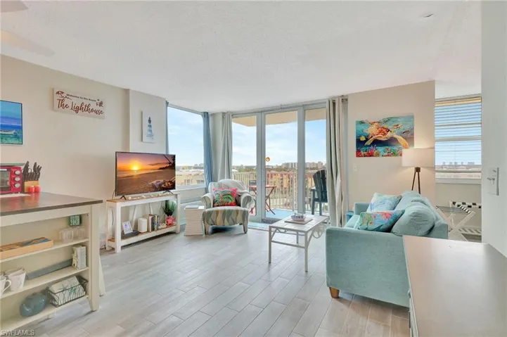 Living area with floor to ceiling windows, wood finish floors, and a textured ceiling