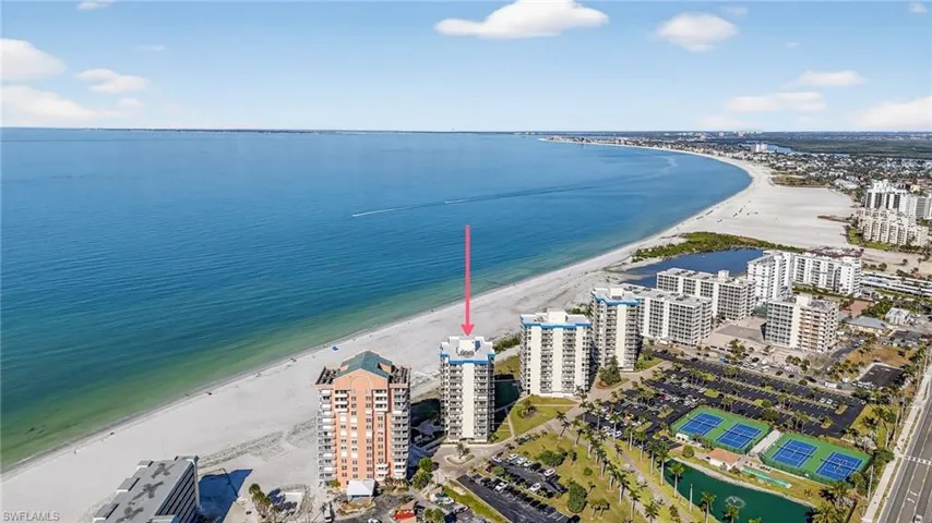 Bird's eye view of apartment complex / building and waterfront with a beach