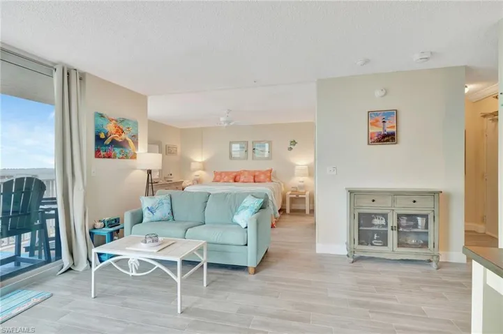 Living area with floor to ceiling windows, wood finish floors, and a textured ceiling