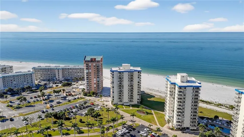 Bird's eye view of apartment complex / building and waterfront with a beach