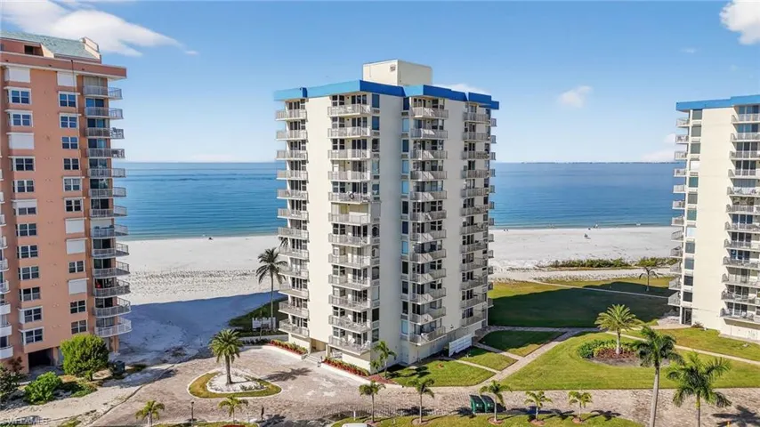 View of apartment building / complex with view of water and beach